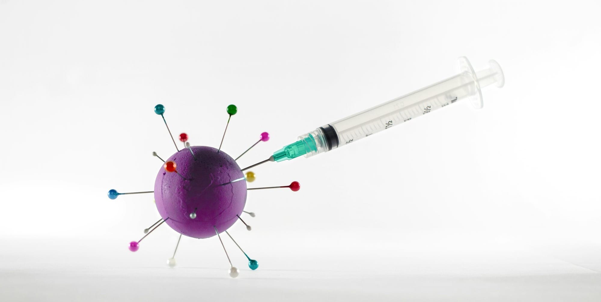 white and green syringe on white surface