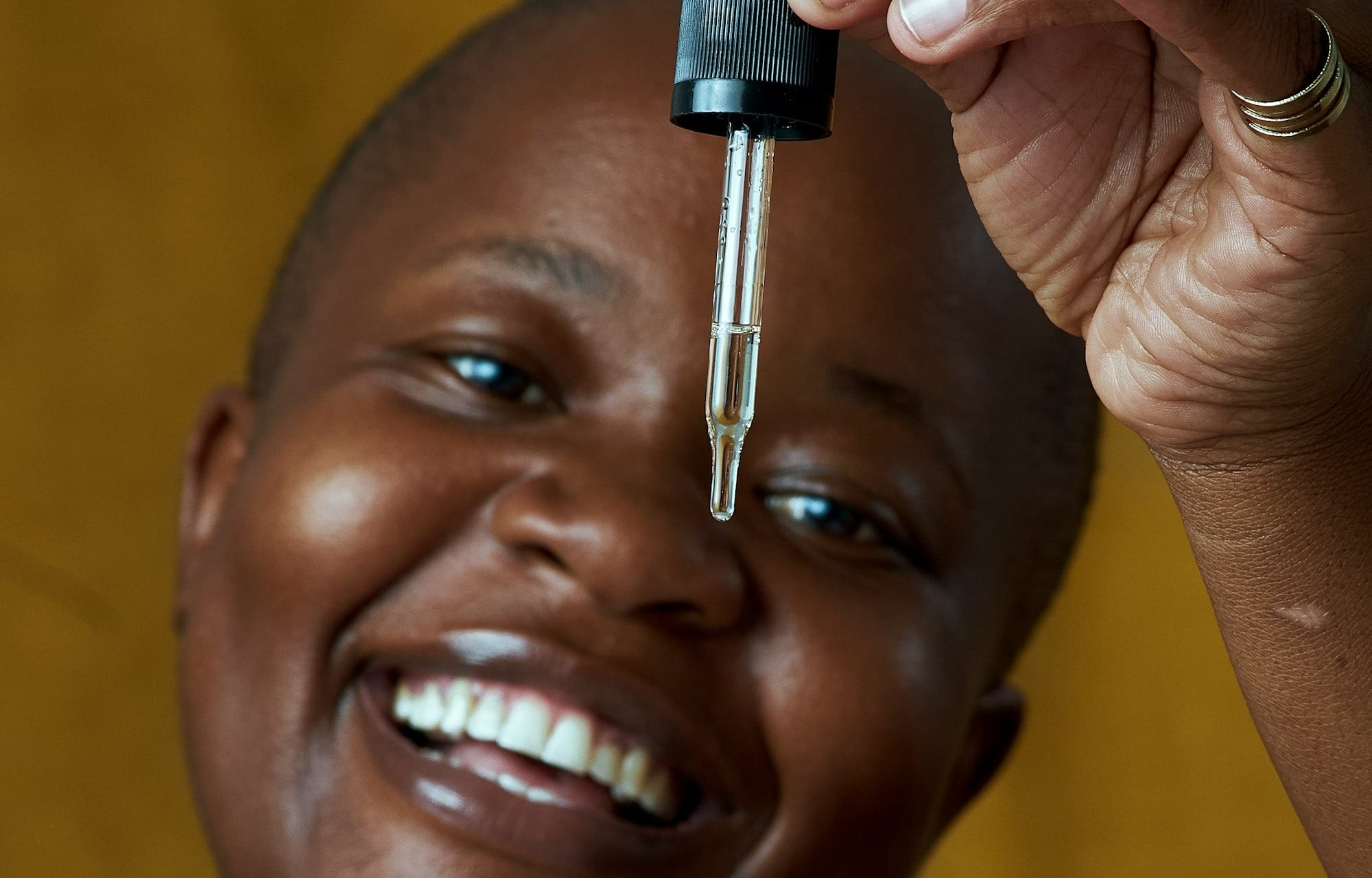 a smiling woman holding a bottle of medicine