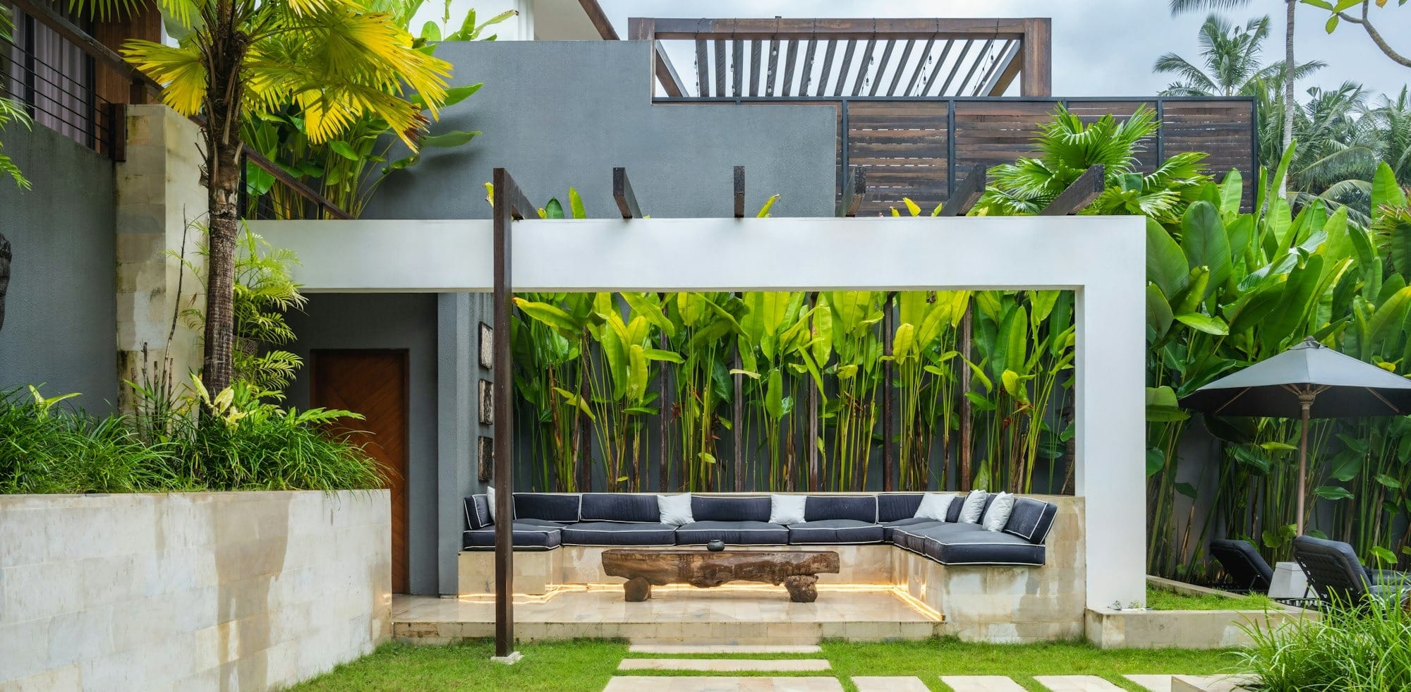 A backyard with a stone path leading to a covered patio